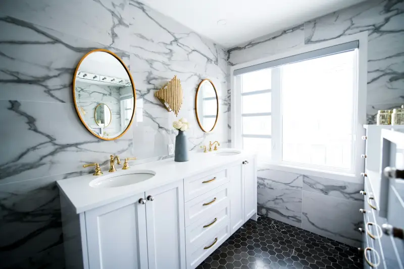 arredare il bagno bianco con doppio lavabo, marmo e oro