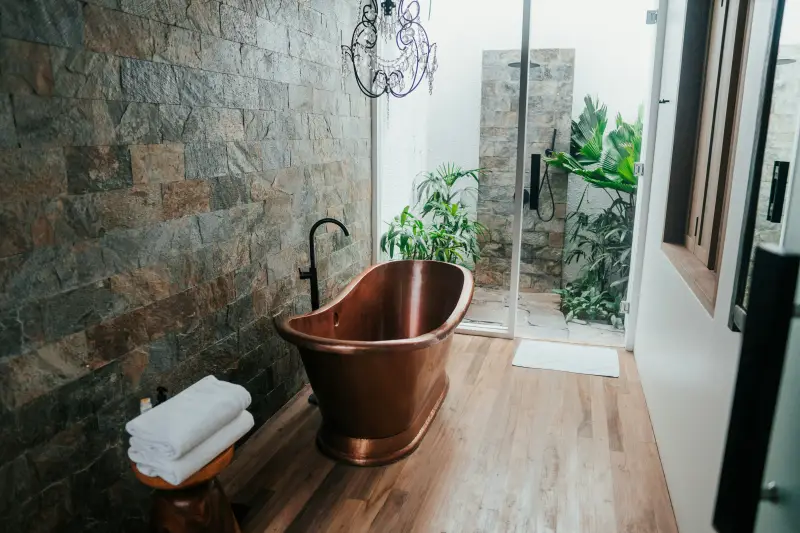 arredare il bagno rustico vasca freestanding in rame e parete pietra