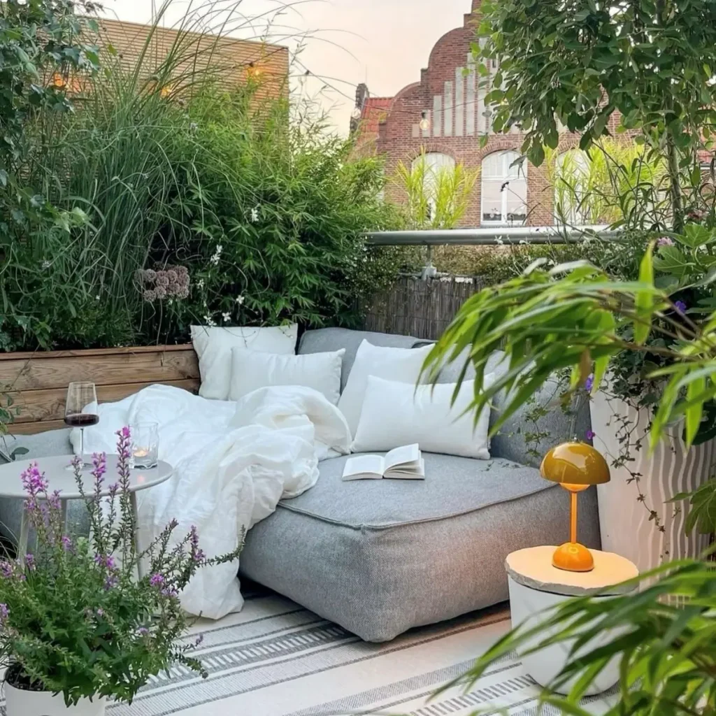 idee per arredare il terrazzo: terrazzo con piante, pouf e lampada